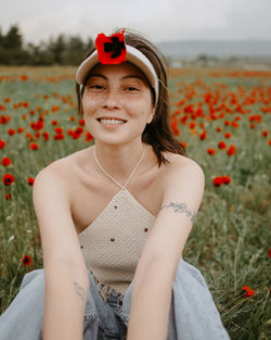 Portrait of young woman standing on field