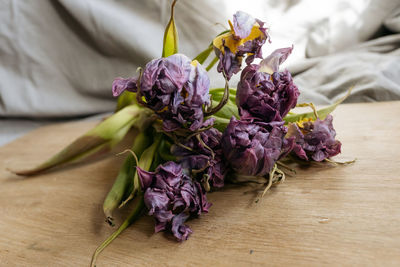 Bouquet of purple tulips laying on a wooden table