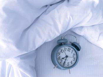 High angle view of clock on bed