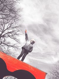 Low angle view of person paragliding against sky