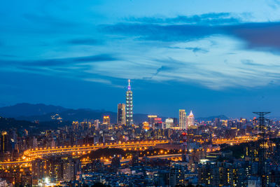 Illuminated cityscape against sky at night