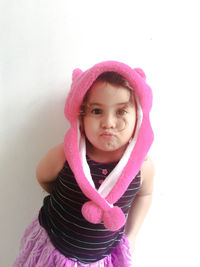 Portrait of smiling girl against pink wall