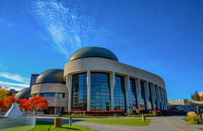 Low angle view of modern buildings against blue sky