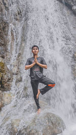 Full length portrait of man standing on rock