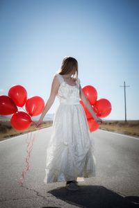 Rear view of woman with red balloons