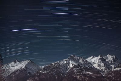 Aerial view of snowcapped mountain against sky at night