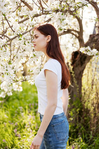 Young woman standing against trees