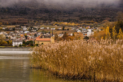 Scenic view of river by town against sky