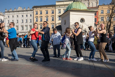 People standing on street against buildings in city