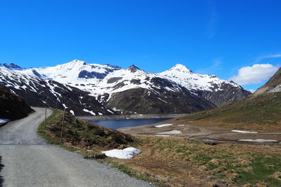 Scenic view of snowcapped mountains against blue sky