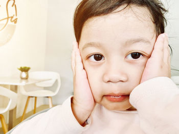 Close-up portrait of cute girl at home