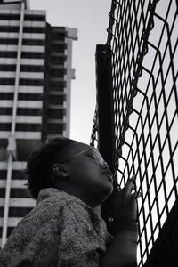 Low angle view of woman looking at modern buildings in city