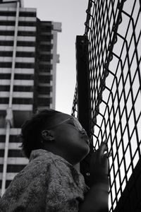 Low angle view of woman looking at modern buildings in city