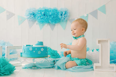 A one-year-old boy tries his first birthday cake. anniversary party