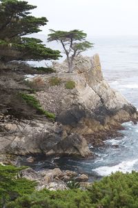 Rock formation by sea against sky