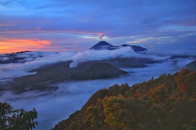 Scenic view of volcanic mountain against sky during sunset