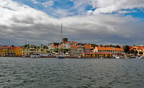 Houses by sea against sky in town