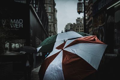 Tilt image of wet street amidst buildings in city during monsoon