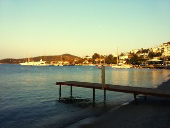 Pier in calm sea against clear sky