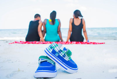 Women wearing sunglasses on beach against sky