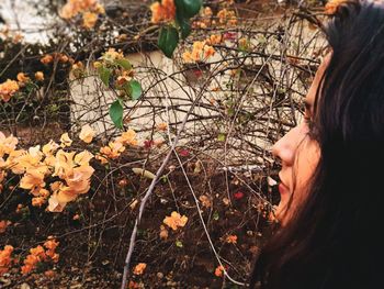 Close-up of woman hand with flowers in autumn leaves