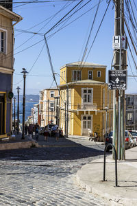 Street by buildings in city against sky