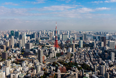 Aerial view of buildings in city against cloudy sky