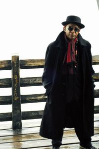 Portrait of man standing by railing against sky