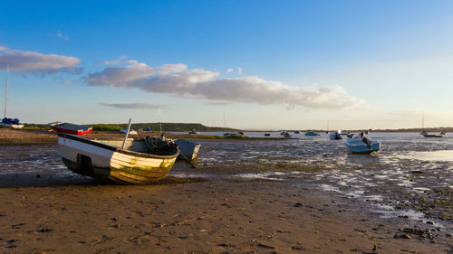 Boats moored on beach against sky