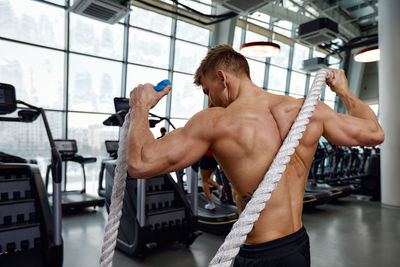 Low angle view of young man exercising in gym