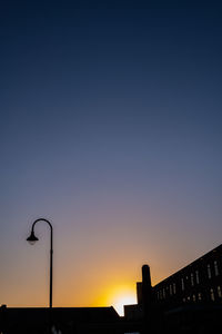 Street lights against clear sky at sunset
