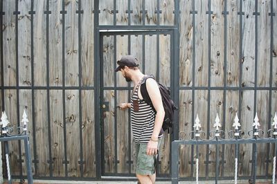 Man standing holding wooden door