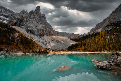 Scenic view of lake by mountains against sky