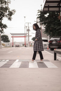 Full length of woman walking on footpath