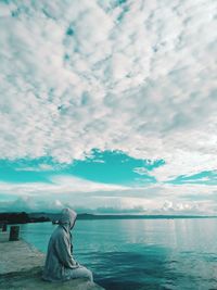 Rear view of woman looking at sea against sky