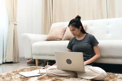 Young woman using laptop at home