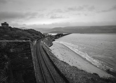 Railroad tracks by mountains against sky