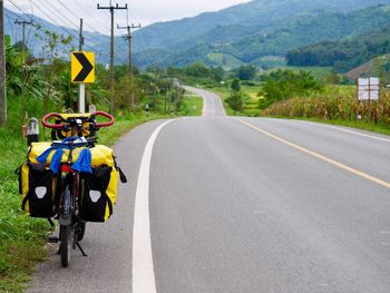 Rear view of man riding bicycle on road, touring bike 