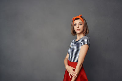 Portrait of woman standing against wall