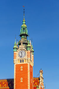 Low angle view of clock tower against clear blue sky