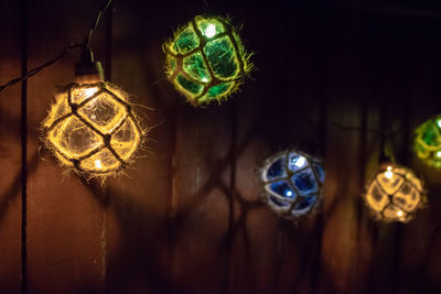 Close-up of illuminated lighting decoration hanging in darkroom