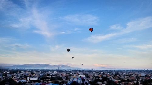 Hot air balloons on beach against sky