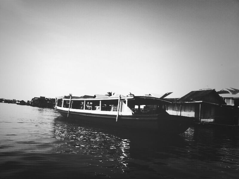 water, clear sky, waterfront, transportation, nautical vessel, copy space, built structure, boat, architecture, mode of transport, sea, building exterior, river, rippled, reflection, travel, moored, nature, outdoors, day