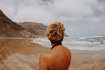 Rear view of woman looking at sea against sky