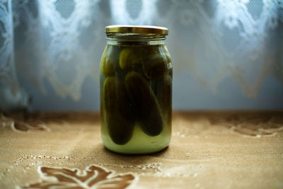 Cucumbers in jar on table