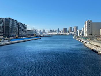 Modern buildings in city against clear blue sky
