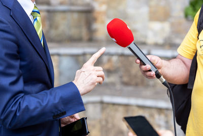 Midsection of man holding umbrella