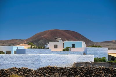 View of houses against mountain and sky