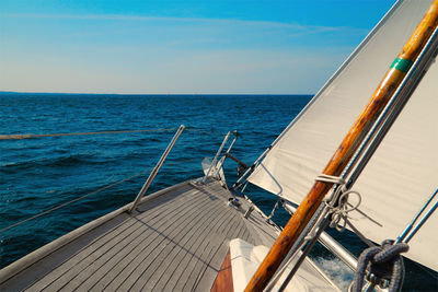 Sailboat sailing on sea against blue sky