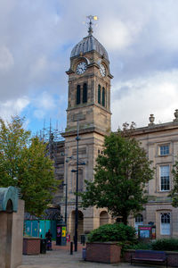 Low angle view of trees and building against sky